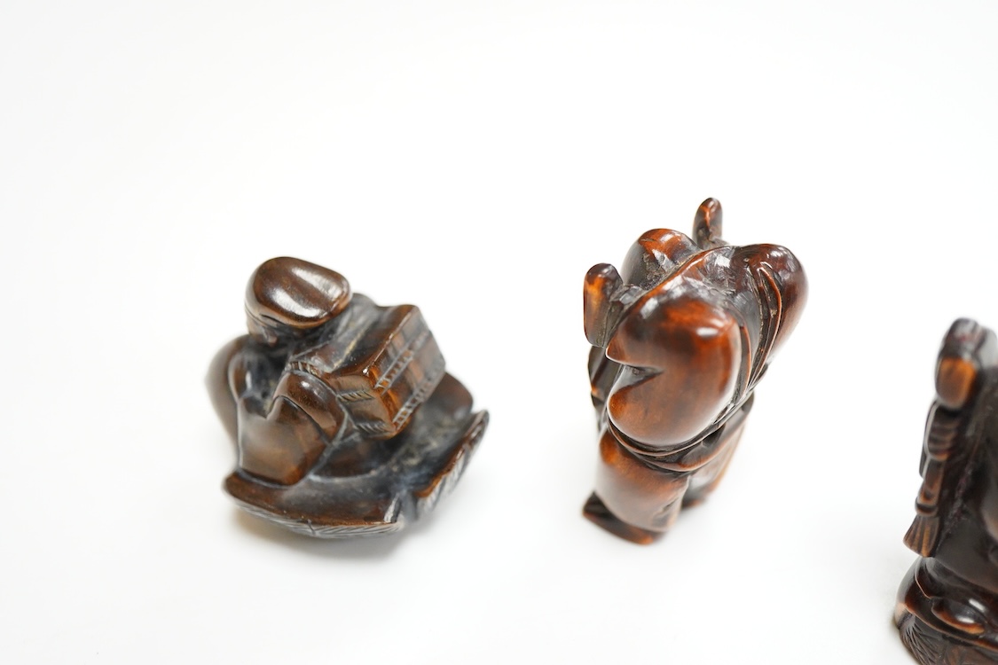 Four Japanese carved wood netsuke to include two elders and a novelty figure seated on a bird, largest 5cm high